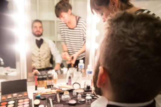 A man and women standing infront of a Makeup vanity Table